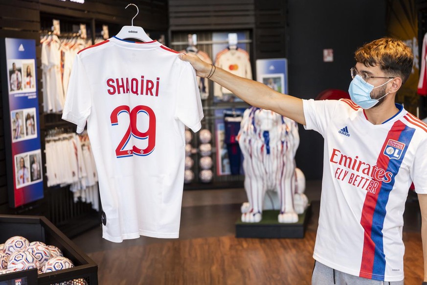 A store employee shows the name and number on the Olympique Lyonnais jersey of Switzerland soccer player Xherdan Shaqiri at the OL Store, in Decines-Charpieu near Lyon, France, Wednesday, August 25, 2 ...