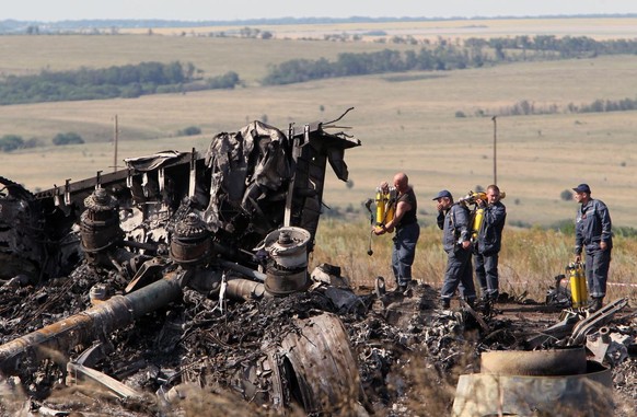 epa04324574 Ukrainians inspect debris at the main crash site of the Boeing 777 Malaysia Airlines flight MH17, which crashed over the eastern Ukraine region, near Grabovo, some 100 km east of Donetsk, ...