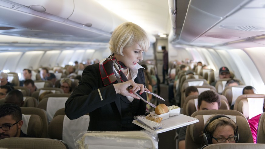 ARCHIVBILD ZUM IMPFOBLIGATORIUM BEI BESATZUNGEN BEI SWISS --- Eine Flugbegleiterin bedient die Passagiere der Economy Class, aufgenommen am 29. April 2013 in einem Flugzeug der Swiss. Die Schweizer Fl ...