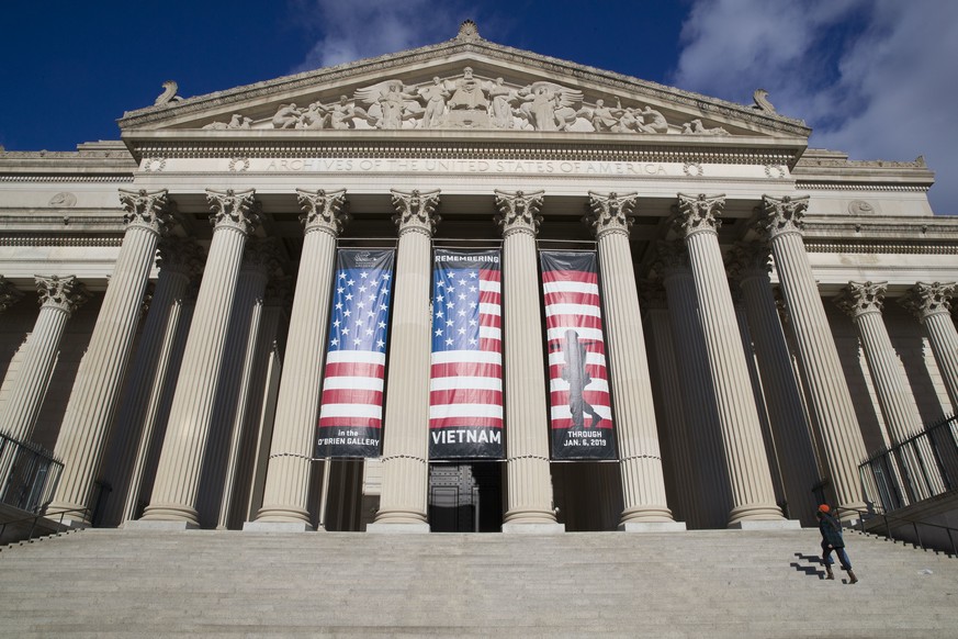 FILE - People walk up the steps even though the National Archives is closed with the partial government shutdown, Dec. 22, 2018 in Washington. While the Archives safeguards precious national documents ...