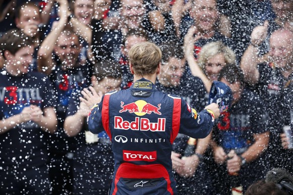 Red Bull driver Sebastian Vettel of Germany, center, is sprayed with champagne after vowing to his team in celebration after the Brazil's Formula One Grand Prix at the Interlagos race track in Sao Pau ...