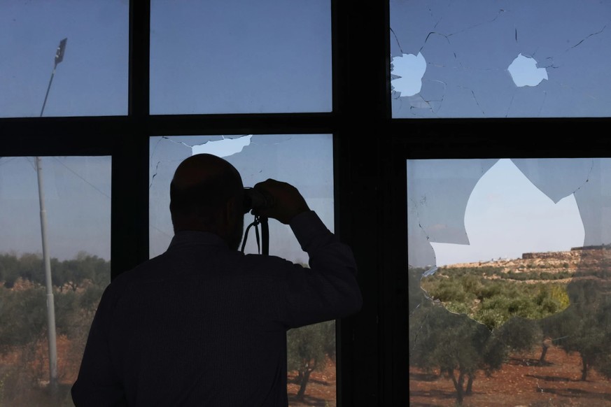 Un Palestinien observe un nouveau poste de colons israéliens en Cisjordanie. Auparavant, des colons avaient incendié plusieurs véhicules dans le village d'Abu Falah.