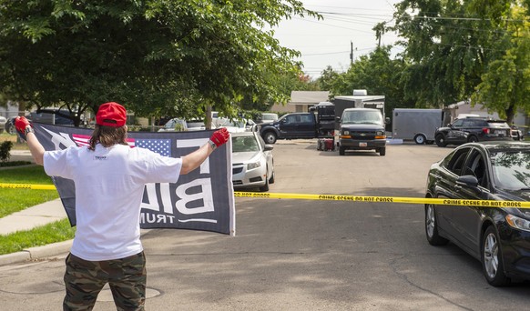 A Provo, dans l'Utah, un homme tient un drapeau «Fuck Biden» non loin de la maison du forcené abattu par la FBI.