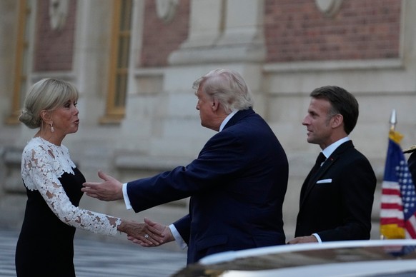 France's President Emmanuel Macron, right, and his wife Brigitte greet U.S. President Donald Trump before a private dinner to celebrate the USA's 250th birthday, at the Palace of Versailles, ...