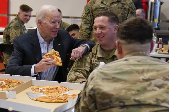 President Joe Biden eats pizza as he visits with members of the 82nd Airborne Division at the G2A Arena, Friday, March 25, 2022, in Jasionka, Poland. (AP Photo/Evan Vucci)
Joe Biden