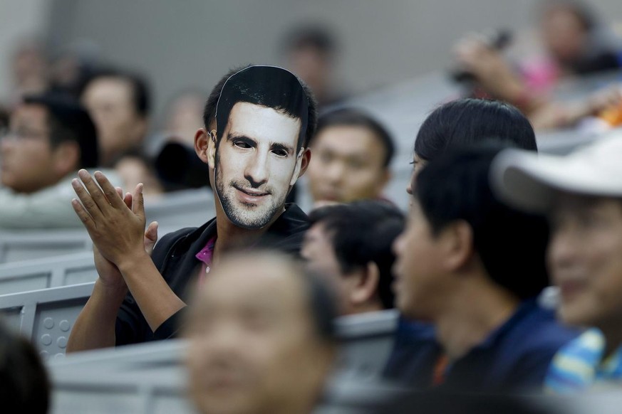 epa03418260 A spectator wears a mask depicting Serbia&#039;s Novak Djokovic as he applauds during the first round match between Djokovic and Michael Berrer of Germany at the China Open in Beijing, Chi ...