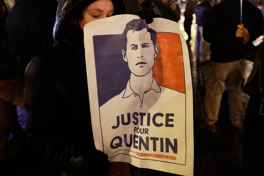 A woman holds a placard reading "Justice for Quentin" as she gathers to pay tribute to far-right student, Quentin Deranque, 23, who died in Lyon from a street beating during clashes between  ...