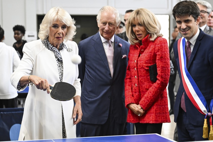 La reine Camilla, accompagnée du roi Charles III et de Brigitte Macron, s'essaie au tennis de table à Paris l'année dernière.