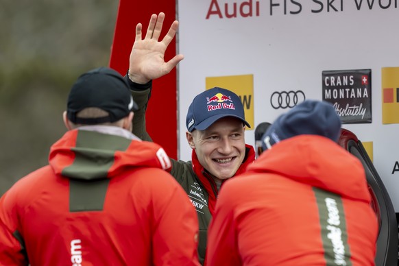 Marco Odermatt of Switzerland in front his teammates waves Swiss fans in the finish area during the men&#039;s Super-G race at the Alpine Skiing FIS Ski World Cup, in Crans-Montana, Switzerland, Sunda ...