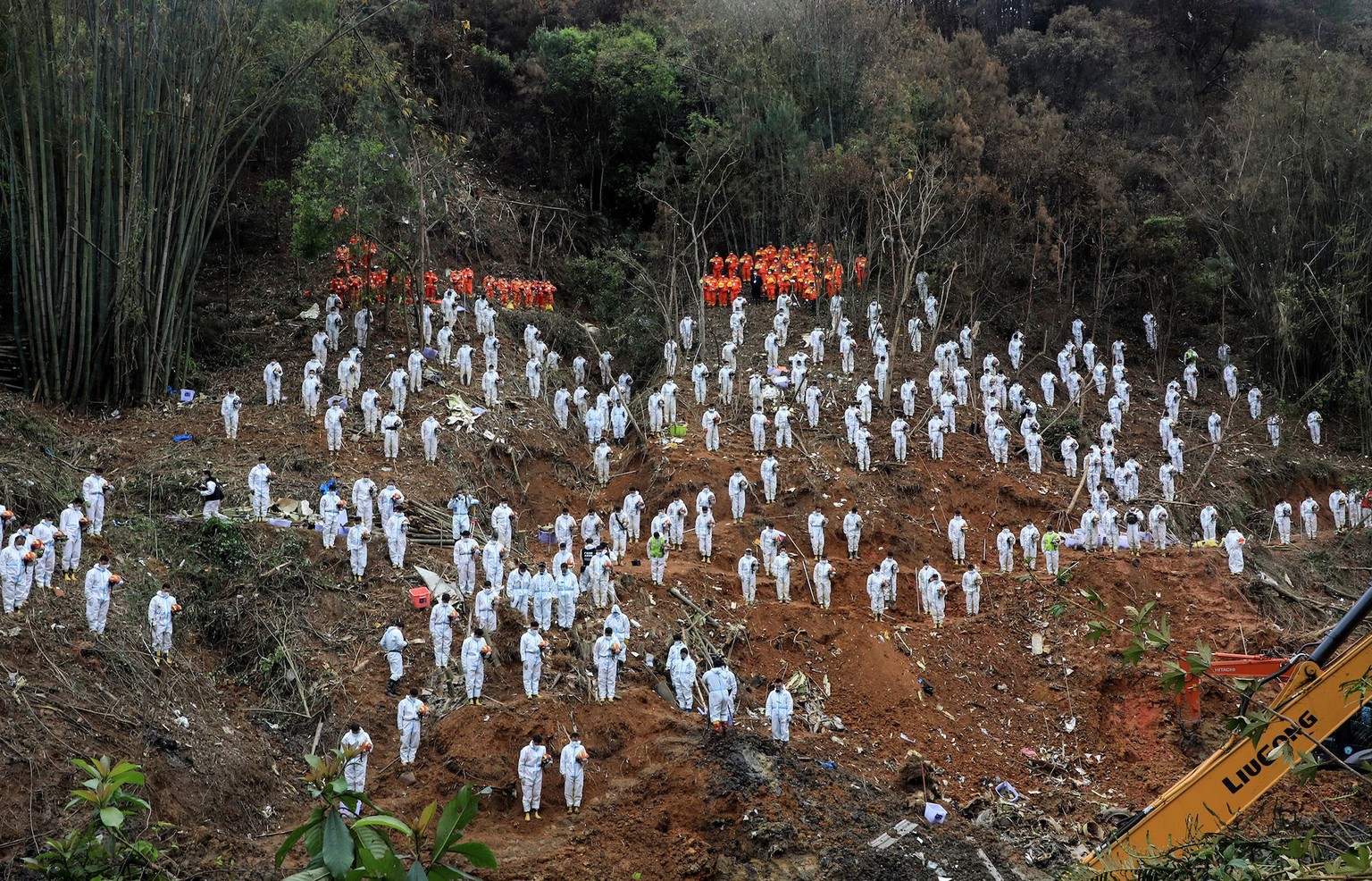 Les sauveteurs rendent un hommage silencieux aux victimes sur le site de l'accident d'avion de China Eastern Airlines dans la région méridionale du Guangxi en Chine, le 27 mars.