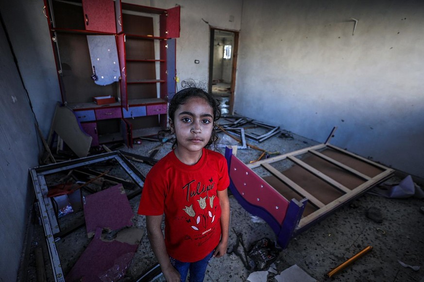 epa09227826 A Palestinian girl poses at her destroyed room in her family destroyed house in Beit Hanoun town, northern Gaza Strip, 24 May 2021 (Issued 25 May 2021). Palestinian families started return ...