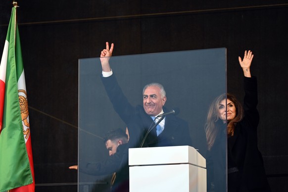 epa12739670 Iranian Crown Prince Reza Pahlavi (C) and his wife Yasmine Pahlavi (R) gesture to supporters during a rally to denounce the Iranian government's crackdown on recent protests and calli ...