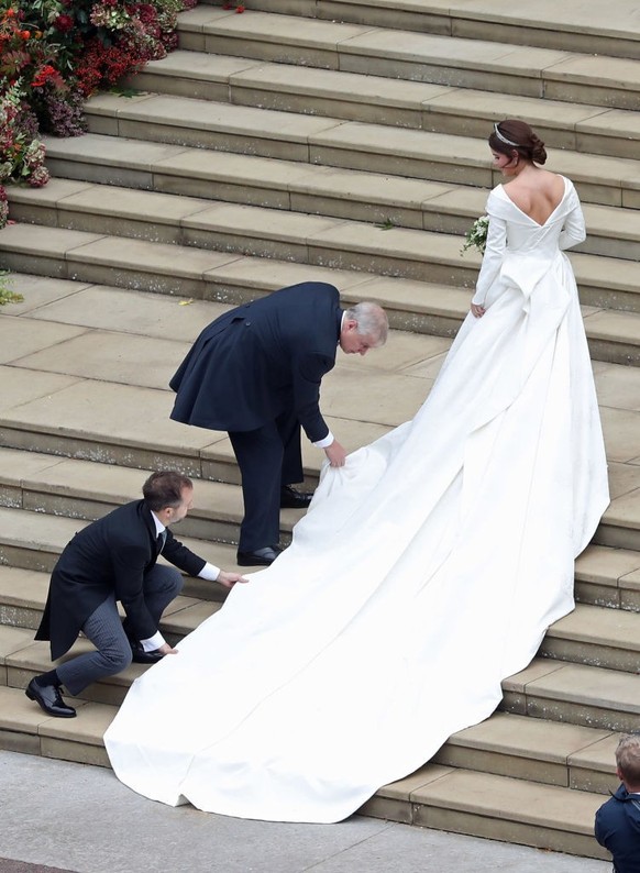 WINDSOR, ENGLAND - OCTOBER 12: Princess Eugenie of York receives help with her train from her father Prince Andrew, Duke of York as she arrives to her wedding to Mr. Jack Brooksbank at St. George&#039 ...