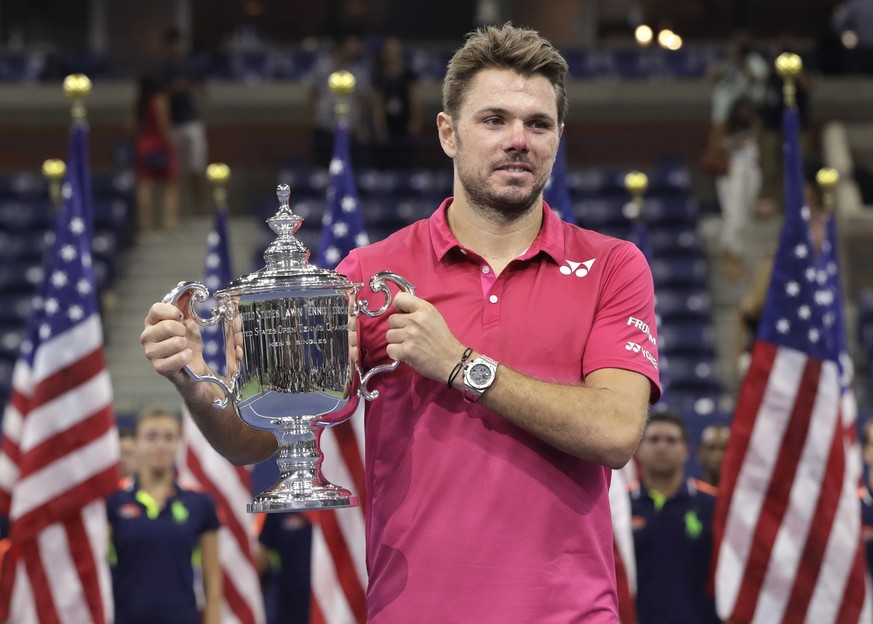 Stan Wawrinka, of Switzerland, holds up the championship trophy after beating Novak Djokovic, of Serbia, to win the men's singles final of the U.S. Open tennis tournament, Sunday, Sept. 11, 2016, ...