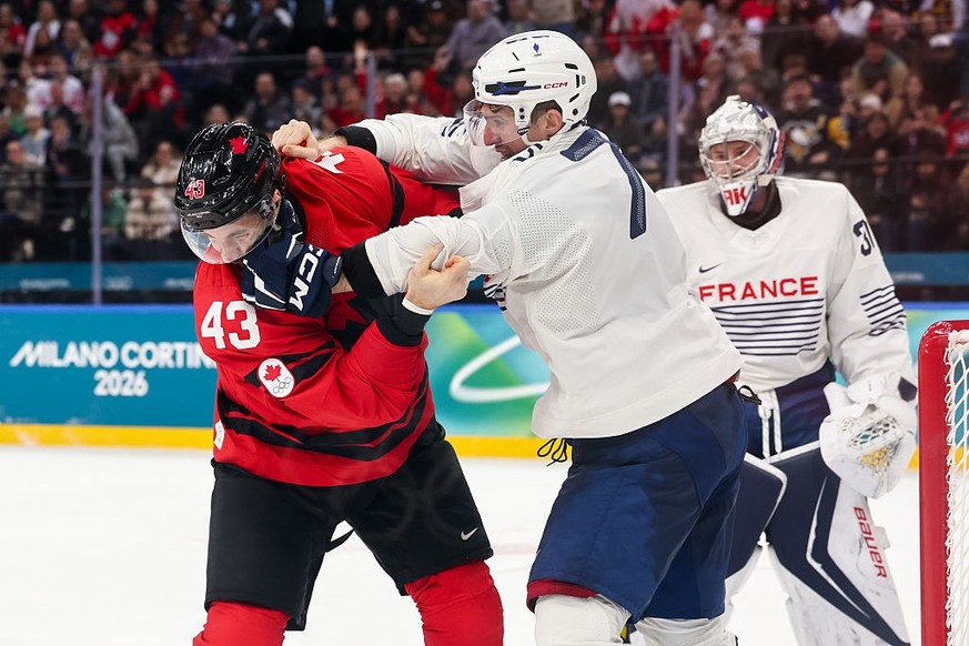 MILAN, ITALY - FEBRUARY 15: Tom Wilson #43 of Team Canada and Pierre Crinon #7 of Team France fight in the third period during the Men's Preliminary Group A match between Canada and France on day ...