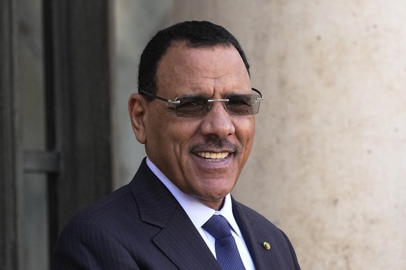 FILE - Niger&#039;s President Mohamed Bazoum smiles before a working lunch with French President Emmanuel Macron, Feb. 16, 2023 at the Elysee Palace in Paris. A court of the West African regional bloc ...