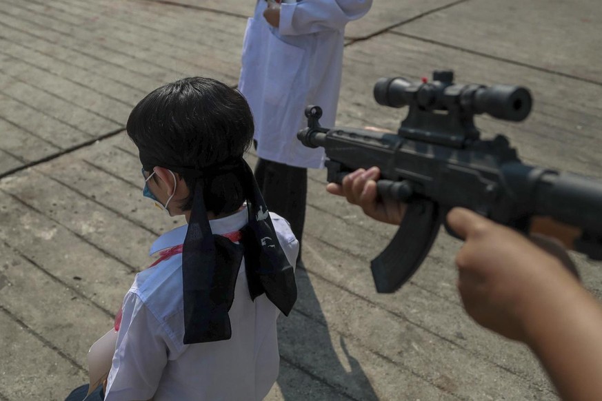 Anti-coup protesters depict the plight of a civil servant being forced to work at gunpoint by the military junta during an anti-coup demonstration in Yangon, Myanmar, Tuesday, Feb. 23, 2021. Protester ...