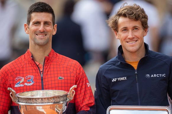 PARIS, FRANCE - JUNE 11. Novak Djokovic of Serbia with the winners trophy and Casper Ruud of Norway with the runners-up trophy after the Men&#039;s Singles Final on Court Philippe Chatrier during the  ...