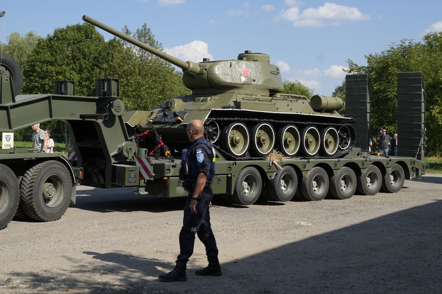 A policeman looks at a trailer transporting a Soviet T-34 tank which was installed as a monument in Narva, arriving to a military museum in Tallinn, Estonia, Tuesday, Aug. 16, 2022. Estonia&#039;s gov ...