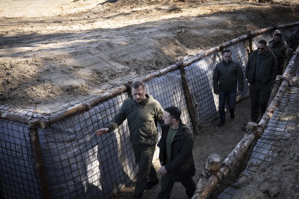 In this photo provided by the Ukrainian Presidential Press Office, Ukrainian President Volodymyr Zelenskyy, foreground right, inspects the fortification lines in Chernihiv region, Ukraine, Friday, Apr ...