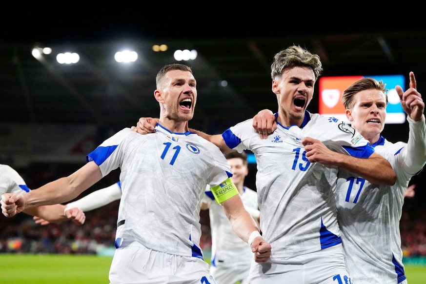 Bosnia and Herzegovina's Edin Dzeko, left, celebrates with team-mates after scoring their side's first goal during the World Cup playoff semifinal soccer match between Wales and Bosnia and H ...