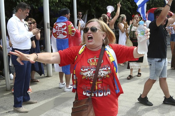 Fans of Serbian tennis star Novak Djokovic react to news of his overturned ruling outside Federal Court ahead of the Australian Open in Melbourne, Australia, Monday, Jan. 10, 2022. An Australian judge ...