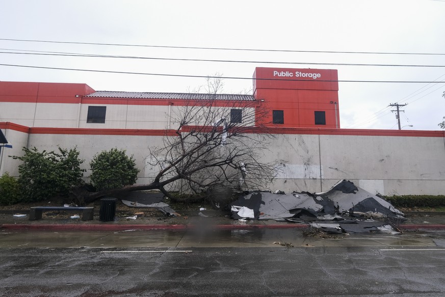 A fallen tree and debris are seen after a possible tornado damaged several buildings Wednesday, March 22, 2023 in Montebello, Calif. (AP Photo/Ringo H.W. Chiu)
