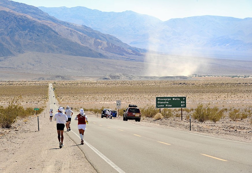 DEATH VALLEY, CA - July 11: With the dust swirling up ahead, a sign shows 87 miles to Lone PIne near the base of Mt. Whitney during the Badwater Ultramarathon in Death Valley, CA, on July 11, 2011. Pa ...