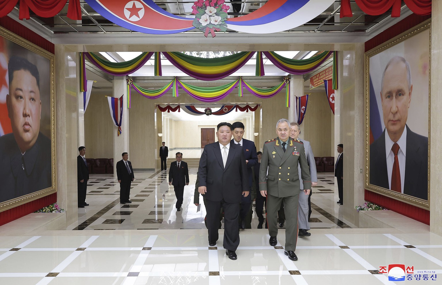 In this photo provided by the North Korean government, North Korean leader Kim Jong Un, center, and Russian Defense Minister Sergei Shoigu, left, head to a banquet hall, at the ruling Workers? Party?s ...