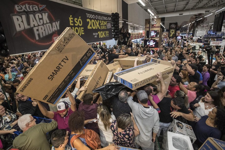 epa06347019 Dozens of Brazilians reach for television sets in a store of Sao Paulo, Brazil, 23 November 2017, during the 'Black Friday' discount deals. According to reports, at least 68 percent of the ...