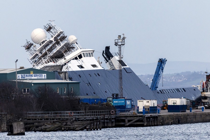 epa10537336 The RV Petrel ship toppled to the side at Imperial Dock in Leith, Edinburgh, Scotland, Britain, 22 March 2023. RV Petrel, a research vessel which was previously owned by the estate of late ...
