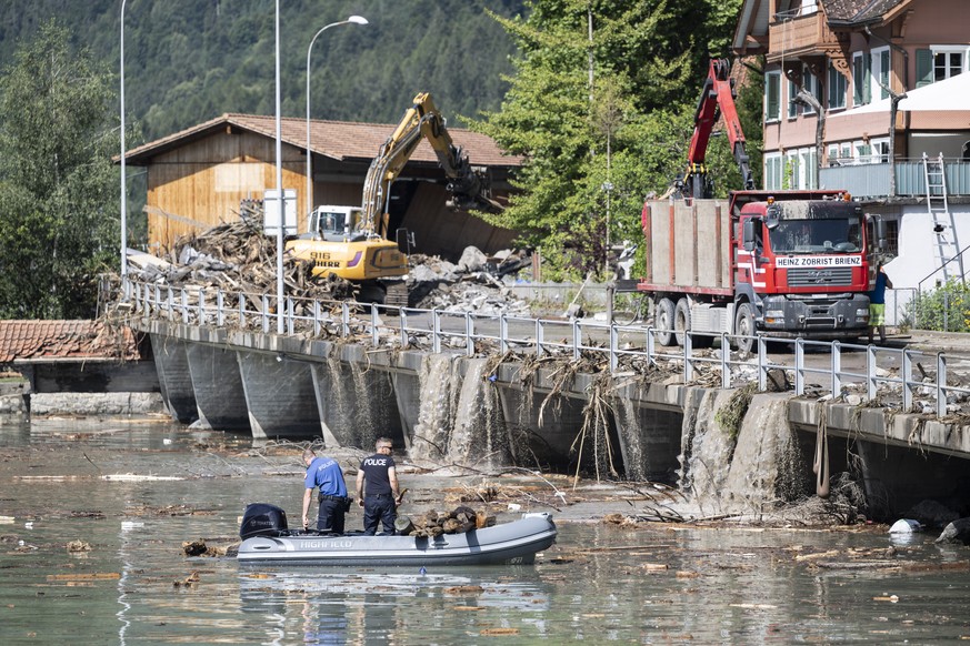 Polizisten ziehen Schwemmholz aus dem Brienzersee, nach dem Unwetter am Vorabend, am Dienstag, 13. August 2024 in Brienz im Berner Oberland. Am Vorabend haben heftige Gewitter einen Murgang ausgeloest ...