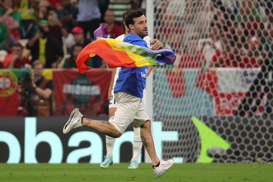 epa10335303 A pitch invader waves a rainbow flag during the FIFA World Cup 2022 group H soccer match between Portugal and Uruguay at Lusail Stadium in Lusail, Qatar, 28 November 2022. EPA/Abir Sultan