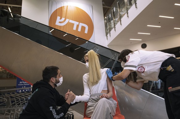 An Israeli paramedic from Magen David Adom medical services, administers a dose of the Pfizer-BioNtech COVID-19 vaccine to a woman at an Ikea store in Rishon Lezion, Israel, Monday, Feb. 22, 2021. Ike ...