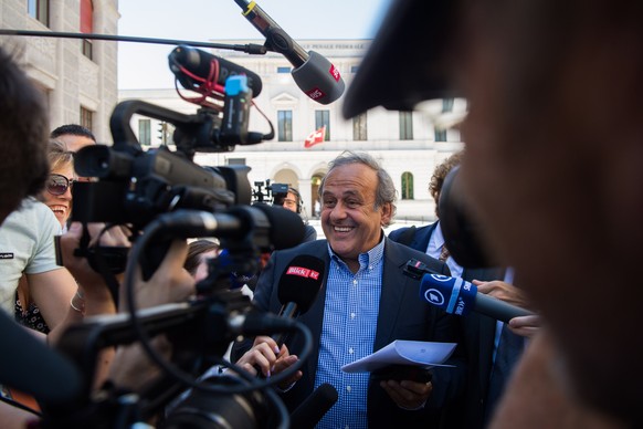 epa10058794 The former president of the the European Football Association UEFA Michel Platini (C) surrounded by media representatives, speaks to the press in front of the Swiss Federal Criminal Court  ...
