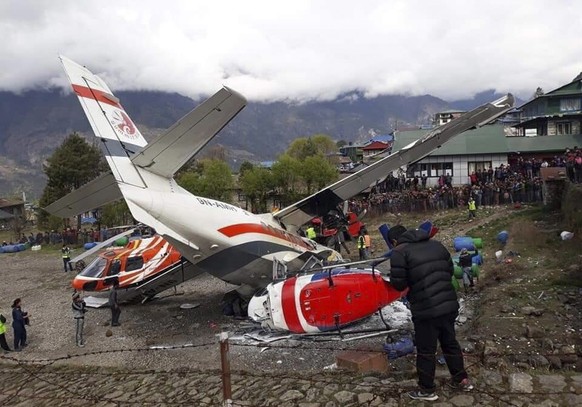 epa07505283 A view of the crash site of a domestic Summit Air aircraft and a helicopter at Lukla Airport, Solukhumbu district, Nepal, 14 April 2019. At least two people died and five were injured in t ...