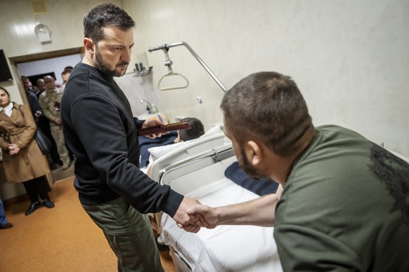 epa11729687 Ukraine&#039;s President Volodymyr Zelensky (C) presents a honor medal to a wounded soldier during his visit at a military hospital with the Danish prime minister, in Kyiv, Ukraine, 19 Nov ...