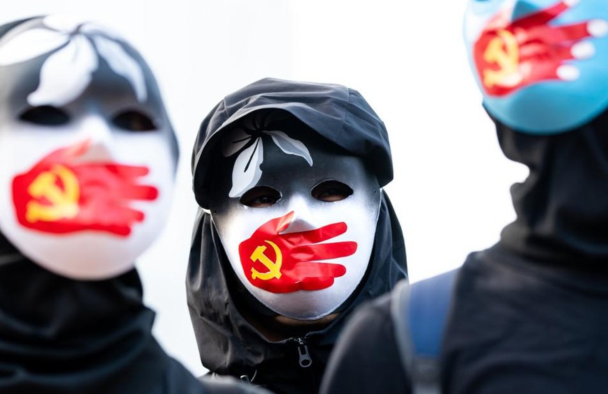 Ces manifestants (à Hong Kong) portent des masques symbolisant le silence du Parti communiste chinois contre les musulmans ouïghours.