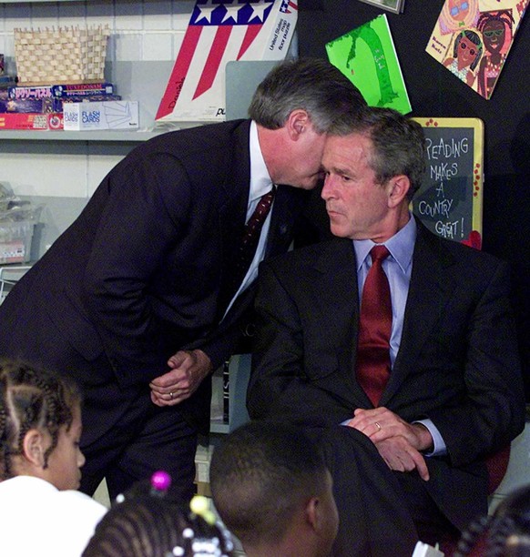 In this Tuesday, Sept. 11, 2001 photo, Chief of Staff Andy Card whispers into the ear of President George W. Bush to give him word of the plane crashes into the World Trade Center, during a visit to t ...