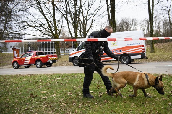 Une policier de la brigade canine de la police cantonale vaudoise marche avec son chien devant l&#039; Ecole professionnelle commerciale de Lausanne (EPCL) lors d&#039;une alerte a la bombe ce mercred ...