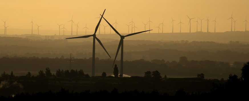 Wind turbines on a hill early Sunday morning near Bad Harzburg, Germany, Sunday, July 17, 2022. (AP Photo/Matthias Schrader)