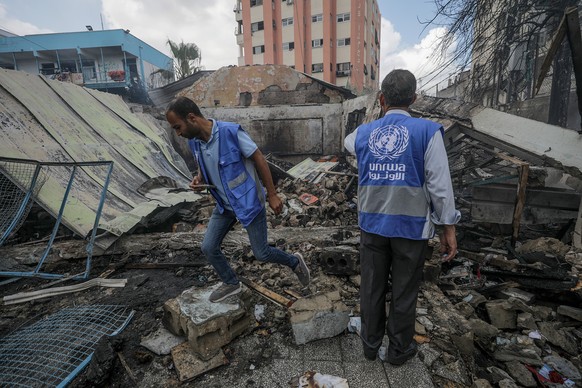 epa11339644 UNRWA employees inspect a destroyed United Nations school following an air strike in Al Nuseirat refugee camp, central Gaza Strip, 14 May 2024. At least six people were killed in the strik ...