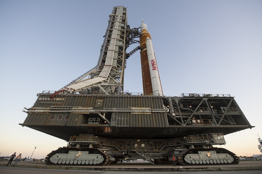 In this image released by NASA, the NASA Artemis rocket, with the Orion spacecraft moves slowly on an 11 hour journey to launch pad 39B, from the the Vehicle Assembly Building, at the Kennedy Space Ce ...