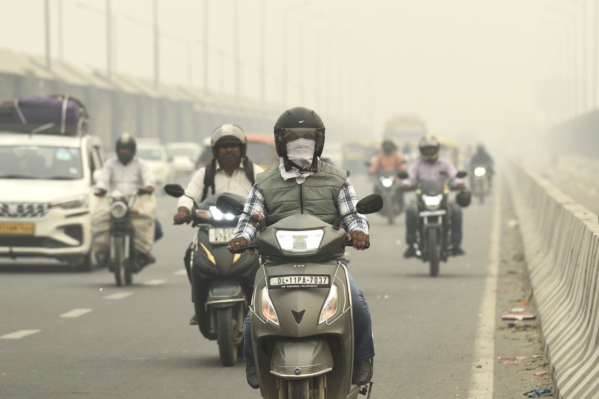 La circulation sur une route enveloppée par le brouillard et le smog à New Delhi.