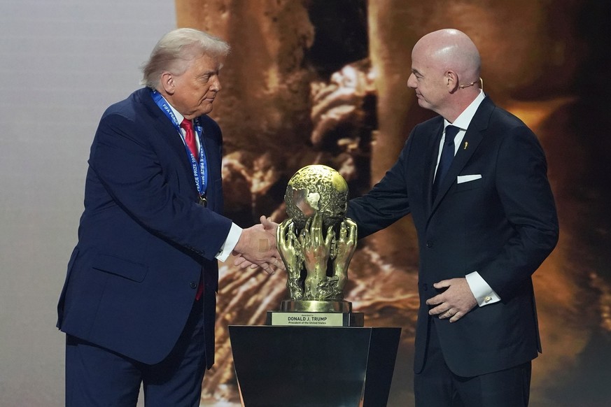 FIFA President Gianni Infantino presents President Donald Trump with the FIFA Peace Prize during the draw for the 2026 soccer World Cup at the Kennedy Center in Washington, Friday, Dec. 5, 2025.(AP Ph ...