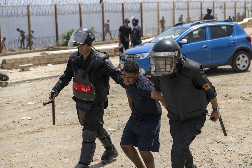 epa13144370 Young men are arrested after attempting to storm the Bab Sebta border crossing near Fnideq, Morocco, 31 July 2026. The disturbances erupted as thousands gathered near the border, and some  ...