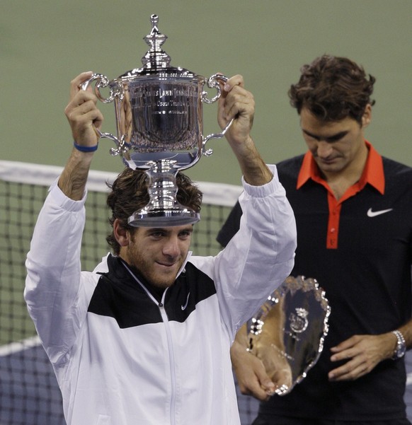 Juan Martin del Potro, of Argentina, holds up the championship trophy after winning the men&#039;s finals championship over Roger Federer, right, of Switzerland, at the U.S. Open tennis tournament in  ...