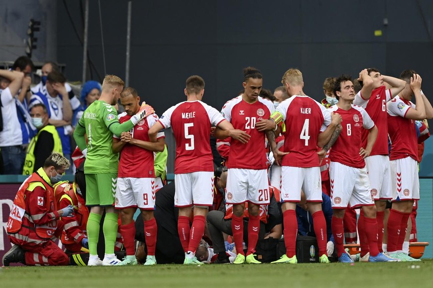 Denmark players make a wall around teammate Christian Eriksen being assisted by medics during the Euro 2020 soccer championship group B match between Denmark and Finland at Parken Stadium in Copenhage ...