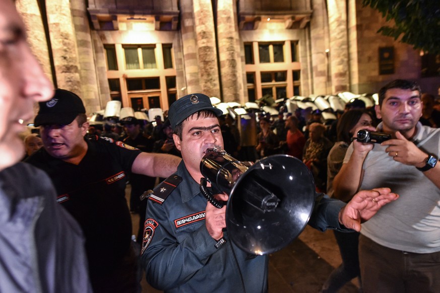 A Erevan, la capitale de l'Arménie, la police tente d'apaiser des manifestants qui protestent contre le gouvernement.