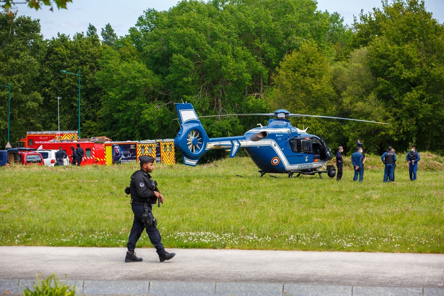 French gendarmes and firemen stand near helicopters in La Chapelle-sur-Erdre, France, Friday, May 28, 2021. An unidentified assailant stabbed a police officer at her station Friday in western France t ...